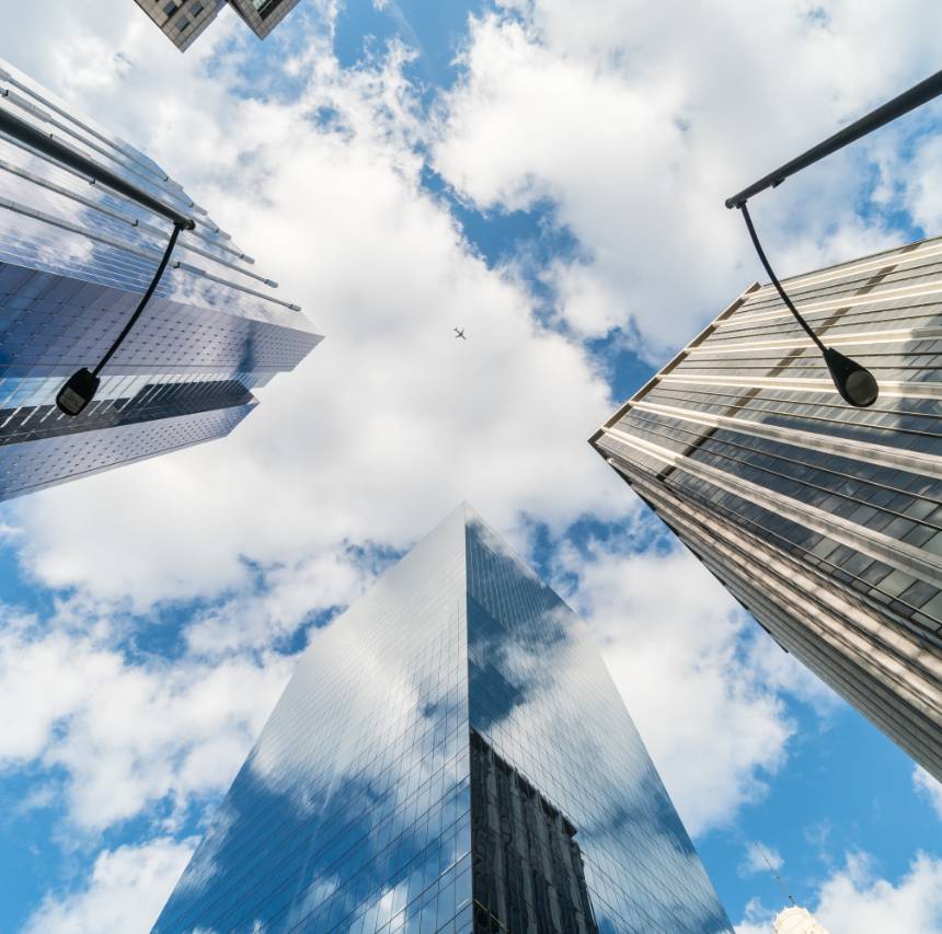 looking upwards to the sky surrounded by tall buildings